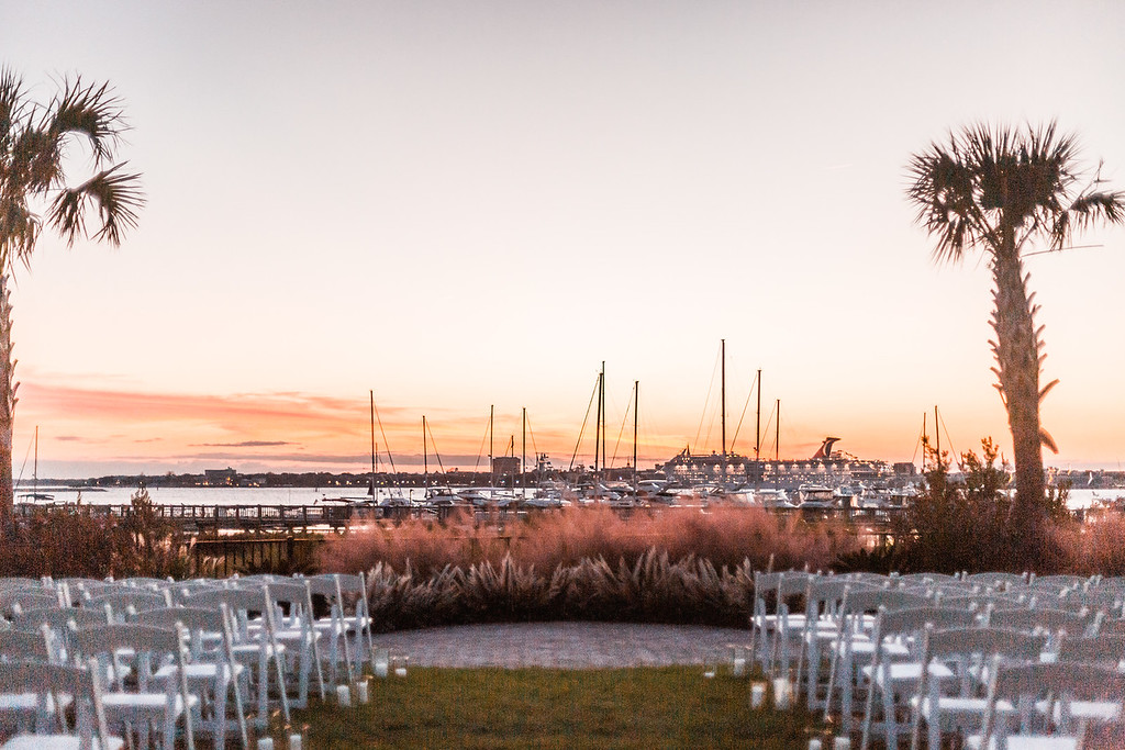 a wedding ceremony setting with boats in the background