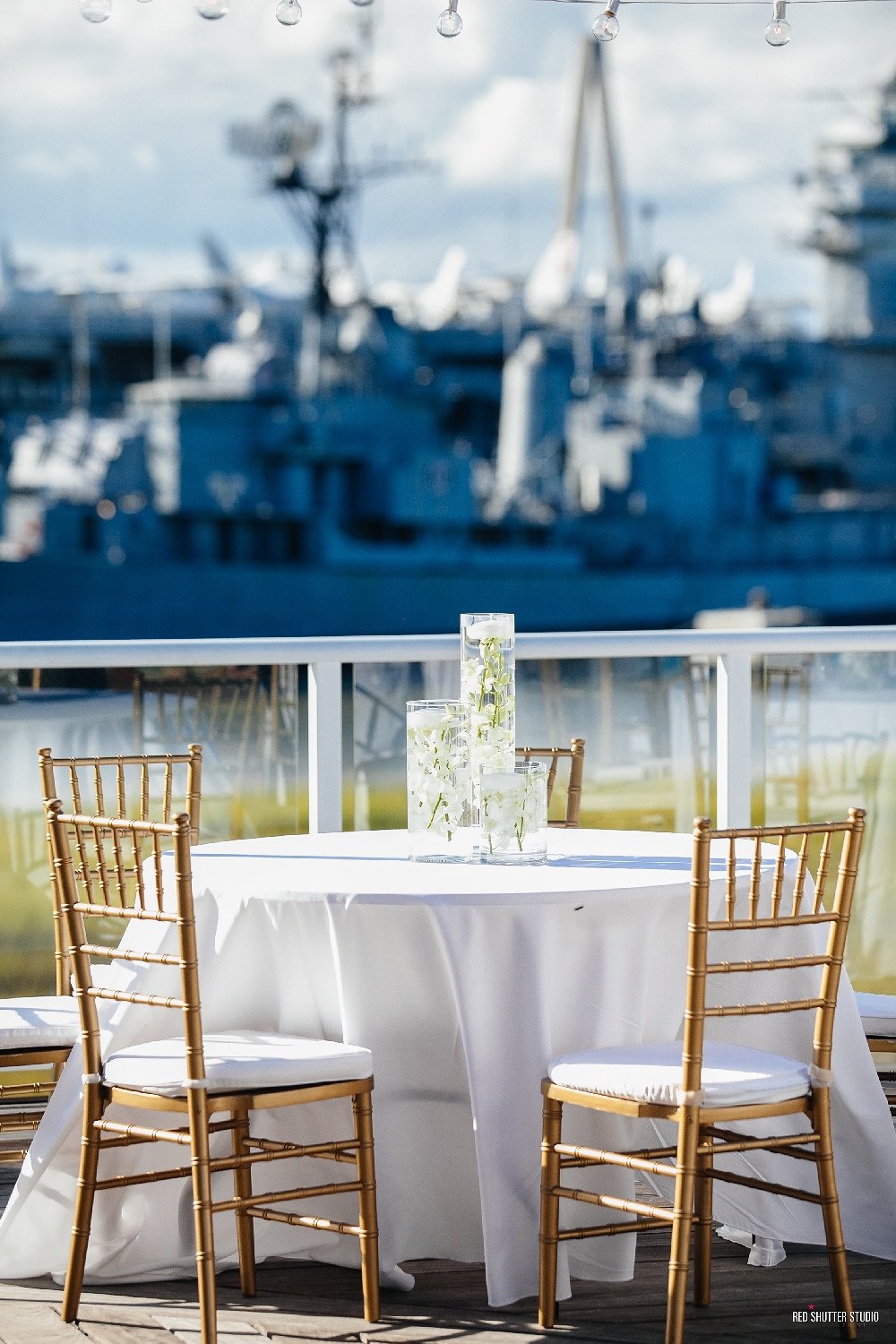 a table set up with chairs and a white tablecloth